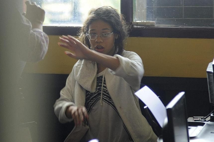 Heather Mack, the daughter of an American woman found dead inside a suitcase on the Indonesian holiday island of Bali, gestures while in custody in a police station in Denpasar on Aug 14, 2014.&nbsp;Indonesian police on Thursday, Aug 14, 2014, ran ps