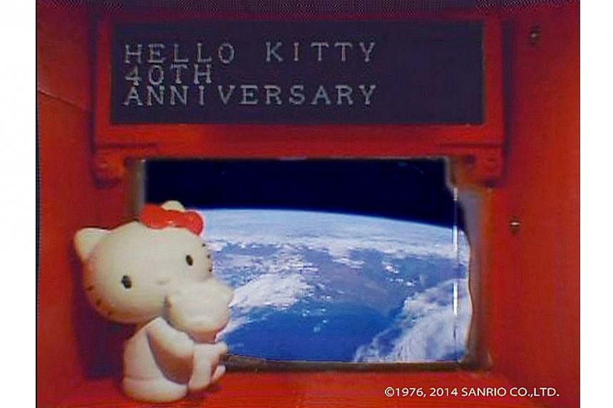 A 4-cm tall Hello Kitty figurine placed under a scrolling display in front of a window of the Hodoyoshi-3 satellite, is seen in what Sanrio said is a still image from a video, made available to Reuters on Aug 14, 2014. Hello Kitty, Japan's ambassador