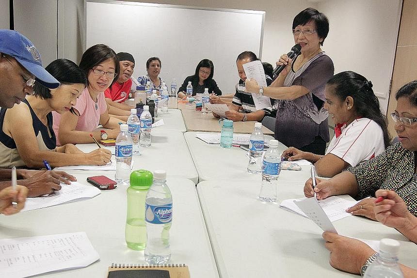 Madam Manuel Stella Consearo (far right), 63, is one member of the group of about 30 participants learning basic conversational Hokkien under the guidance of Madam Ng Lay Geok (standing), 71, at the Nee Soon South Community Club.