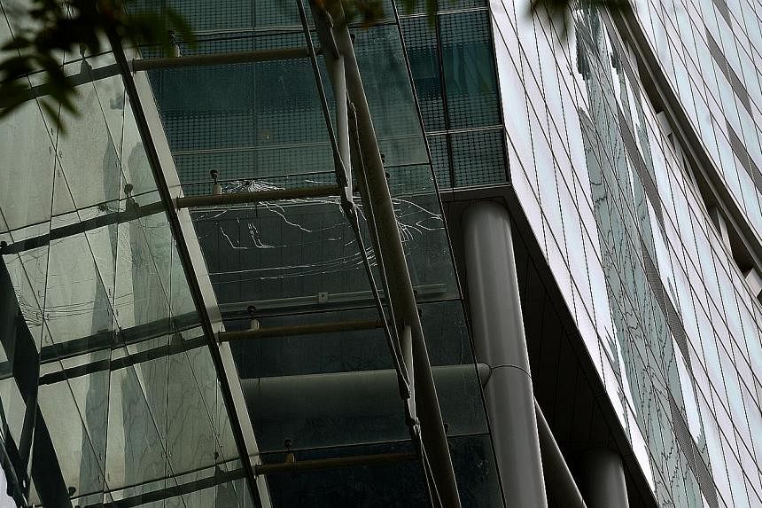 A source says pebbles flung from the fifth-floor sky garden caused the cracks on the external glass roof (left) of the Fusionopolis building and on the glass roof directly above MindChamps pre-school (above).