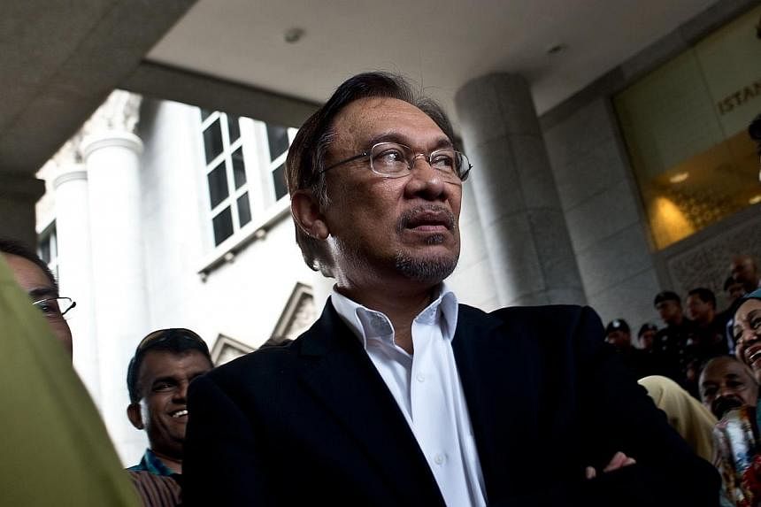 This file picture taken on March 7, 2014 shows Malaysian opposition leader Anwar Ibrahim waiting for his car outside the federal courts in Putrajaya.&nbsp;Malaysia’s highest court on Thursday set a late October hearing date for opposition leader An