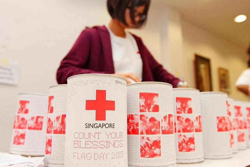 A Singapore Red Cross volunteer organizing the donation tins to be used on its Flag Day held on Jan 26, 2013.&nbsp;The amount of donations to charity last year hit $970 million - about 6 per cent less than the record $1.031 billion raised in 2012. --