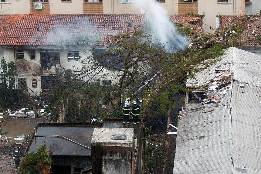 Rescuers work at the site of the crash of the Cessna 560XL aircraft carrying the presidential candidate of the Brazilian Socialist Party Eduardo Campos in Santos, Sao Paulo state, Brazil, on August 13, 2014. The plane failed to land and crashed into 