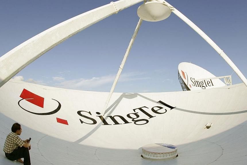 A Singapore Telecommunications Ltd. employee uses his mobile phone while sitting inside one of the company's giant satellite dishes shortly after periodic work to clean it was completed in Singapore on Monday, July 19, 2004.&nbsp;Singapore Telecommun