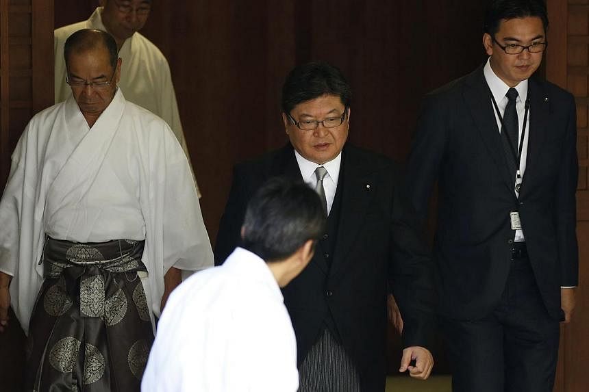 Mr Koichi Hagiuda (centre), an aide to Prime Minister Shinzo Abe and a lawmaker in the ruling Liberal Democratic Party, walks as he visits the Yasukuni Shrine in Tokyo on Aug 15, 2014, to mark the 69th anniversary of Japan's defeat in World War II. -