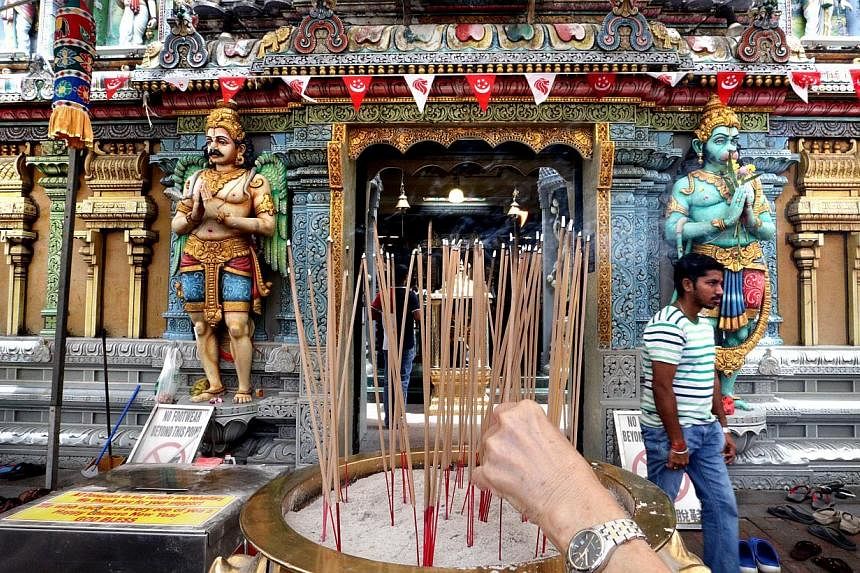 (Above) Besides Hindu worshippers, the Sri Krishnan Temple in Waterloo Street also sees devotees from the Chinese temple next door stopping by to light joss sticks (left) and say quiet prayers. (Far left) Crowds thronging the 130-year-old Kwan Im Tho