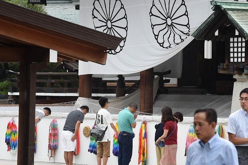 People visit the controversial Yasukuni Shrine in Tokyo on Aug 14, 2014, one day before the 69th anniversary of Japan's surrender in World War II. &nbsp;-- PHOTO: AFP