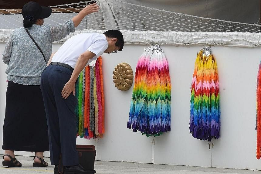 People pray and make offerings as they visit the controversial Yasukuni Shrine in Tokyo on Aug 14, 2014, one day before the 69th anniversary of Japan's surrender in World War II. &nbsp;-- PHOTO: AFP