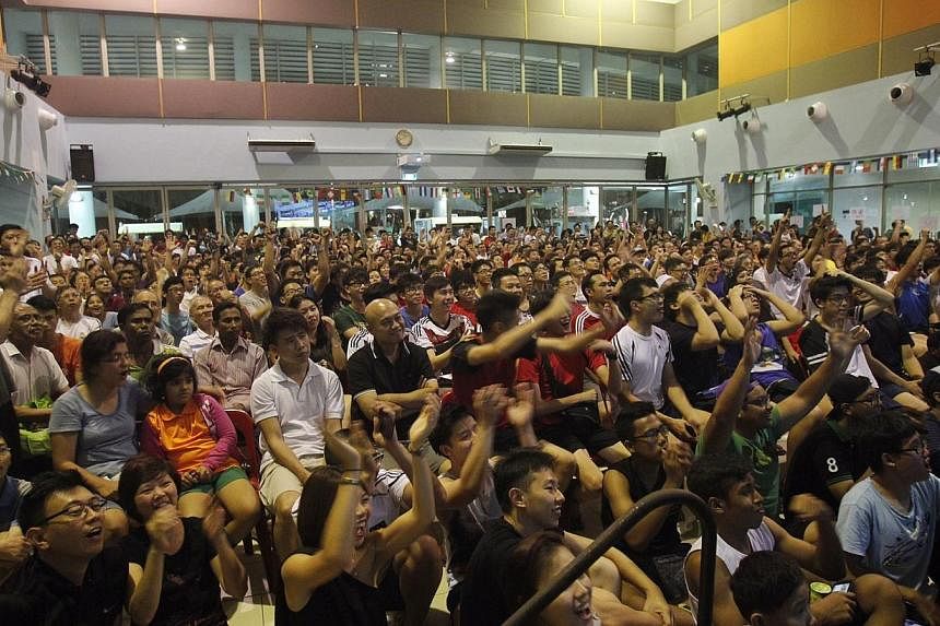 More than 300 football fans react when Germany scored its fourth goal against Portugal in a live screening of the World Cup at Sengkang Community Club on June 17, 2014. -- PHOTO: ST FILE&nbsp;