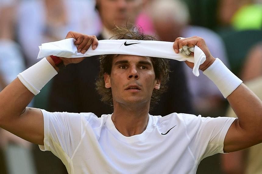 This July 1, 2014 file photo shows Spain's Rafael Nadal as he adjusts his headband between sets during his men's singles fourth round match against Australia's Nick Kyrgios at The All England Tennis Club in Wimbledon, southwest London.&nbsp;-- PHOTO:
