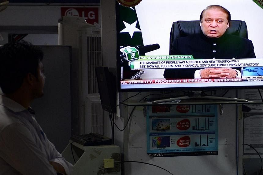A Pakistani man listens to a broadcasted speech by Prime Minister Nawaz Sharif on a television in a electronics market in Islamabad on Aug 12, 2014.&nbsp;The leaders of two Pakistani protest movements vowed on Saturday to keep their protests alive un