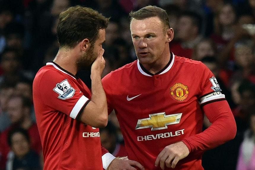 Manchester United's English striker Wayne Rooney (right) speaks to Spanish midfielder Juan Mata before taking a free kick during the pre-season football friendly match between Manchester United and Valencia at Old Trafford in Manchester. north west E
