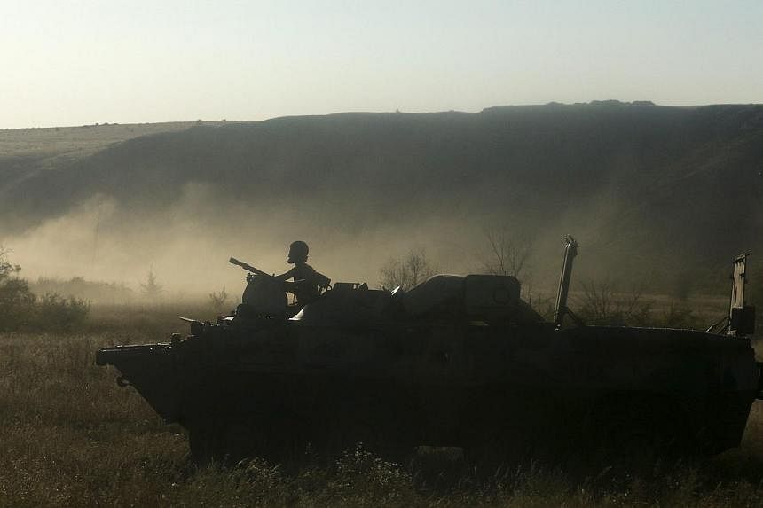 A Russian serviceman rides atop an armoured personnel carrier (APC) through a field outside Kamensk-Shakhtinsky, Rostov Region, on Aug 15, 2014. Ukraine said on Friday it had destroyed part of a Russian armoured column that entered onto its territory