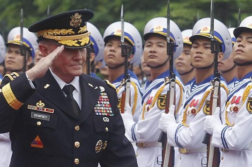 US Chairman of the Joint Chiefs of Staff General Martin Dempsey reviews the guard of honour during a welcoming ceremony at Vietnam's Defence Ministry in Hanoi on Aug 14, 2014. -- PHOTO: REUTERS