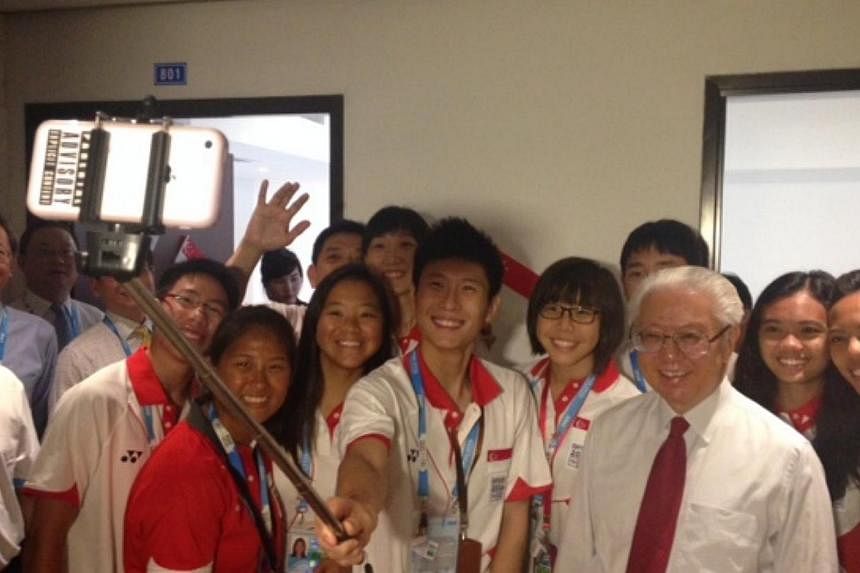 Team Singapore youth athletes take a selfie with President Tony Tan Keng Yam, after he visited their accommodation at the Youth Olympic Games Village. -- ST PHOTO: WALTER SIM