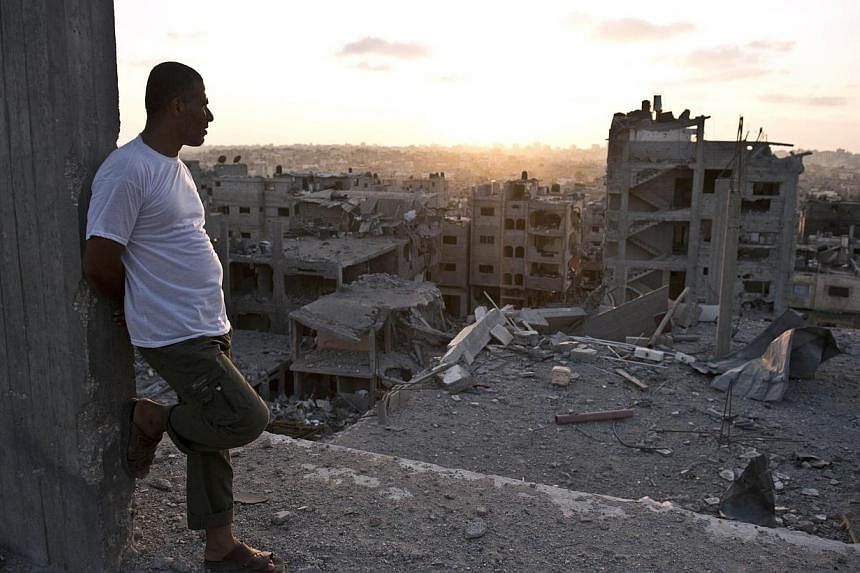 A Palestinian man leans against a concrete post as he looks out at the rubble of apartment buildings destroyed during fighting between Hamas militants and Israel in the Al-Shaas neighbourhood, in the north of the Gaza Strip, on Aug 16, 2014.&nbsp;Isr