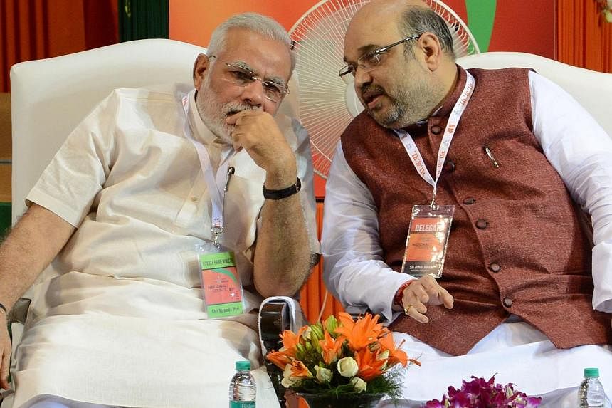 Bharatiya Janata Party (BJP) President Amit Shah (right) talks with Indian Prime Minister Narendra Modi at a BJP National Council meeting at Jawaharlal Nehru Stadium in New Delhi on Aug 9, 2014.&nbsp;Several members of India's most powerful right-win