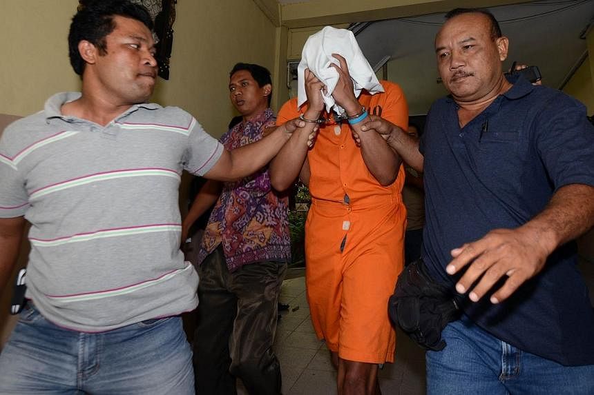 Police escort suspect Tommy Schaffer (centre), suspected in the murder of Sheila von Wiese Mack, while in custody at Bali police hospital in Denpasar on the Indonesian resort island of Bali on August 15, 2014.&nbsp;Bali police chief Albertus Julius B