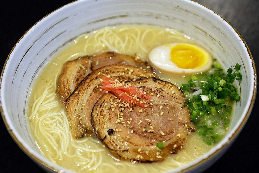 Professionals and home cooks alike can learn how to make ramen at The Eureka Cooking Lab, such as tying the pork belly with cotton twine, torching the charsiu to char the fat before serving and producing the perfect egg (above). -- ST PHOTO: RAJ NADA