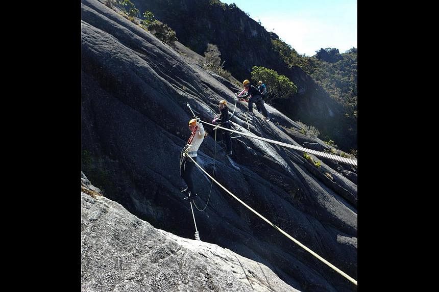 Via Ferrata or Iron Route in Italian (above and left) begins at 3,411m and takes trekkers acoss the steep rockface of Mount Kinabalu. Via Ferrata trekkers cross a monkey bridge along Walk The Torq, a beginner's route (right). Via Ferrata trekkers cro