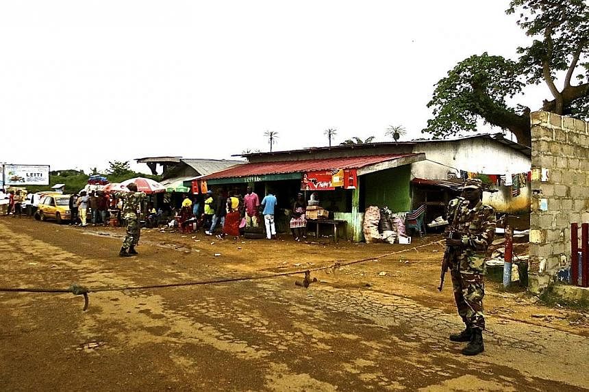 Soldiers from the Liberian army monitor a border checkpoint as part of Operation White Shield to control the Ebola outbreak, at an entrance to Bomi County in northwestern Liberia on Aug 11, 2014.&nbsp;Armed men claiming that "there's no Ebola" in Lib