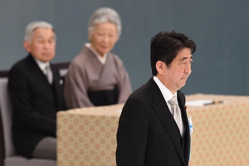 Japanese Prime Minister Shinzo Abe (R) walks past Emperor Akihito (L) and Empress Michiko (C) after his speech during an annual memorial service for war victims in Tokyo on Aug 15, when the country marked the 69th anniversary of its surrender in Worl
