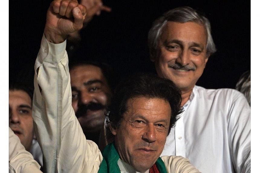 Pakistani cricketer-turned politician Imran Khan raises his fist as he attends a rally after a populist cleric issued a 48-hour ultimatum demanding the arrest of Prime Minister Nawaz Sharif, on Aug 17, 2014 in Islamabad.&nbsp;Pakistan's opposition pa