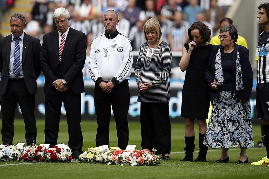 Relatives of Malaysia Airlines Flight MH17 victims Liam Sweeney and John Alder observe a minute's silence in their memory before Newcastle United's English Premier League soccer match against Manchester City at St James' Park in Newcastle upon Tyne, 