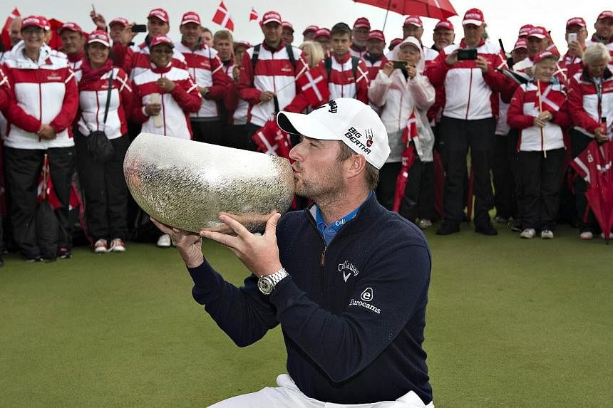 Scottish golfer Marc Warren kisses his trophy after winning the finals of the European Golf Tour "Made in Denmark 2014" at Himmerlands Golf and Spa in Gatten on August 17, 2014. Warren won his third European Tour title on Sunday when he clinched the 