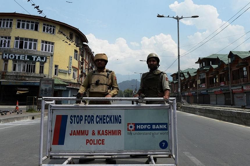 Indian police standing guard at a checkpoint during a curfew in Srinagar, Kashmir on August 15, 2014. -- PHOTO: AFP&nbsp;