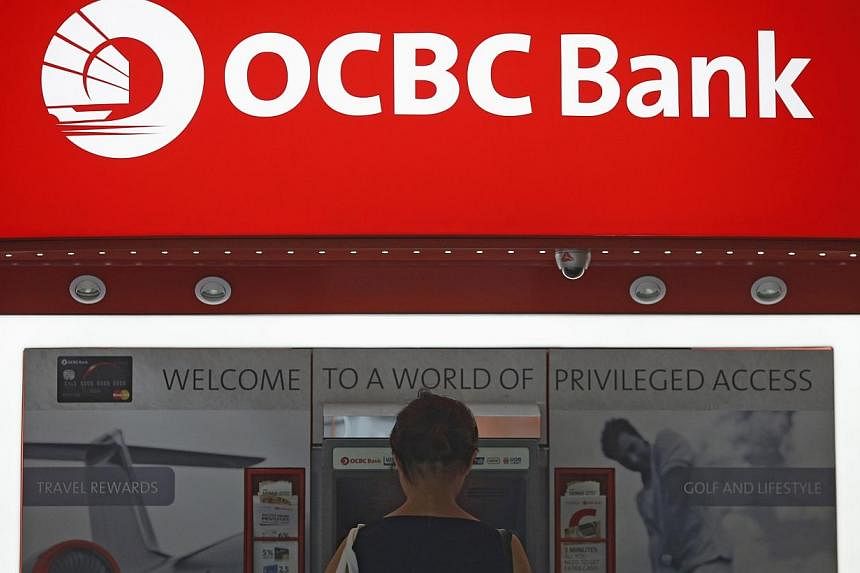 A woman uses an Oversea-Chinese Banking Corp (OCBC) automated teller machine in Singapore's financial district on Aug 5, 2014.&nbsp;Oversea-Chinese Banking Corp, Singapore's second-biggest lender, said it plans to raise $3.37 billion in a rights issu
