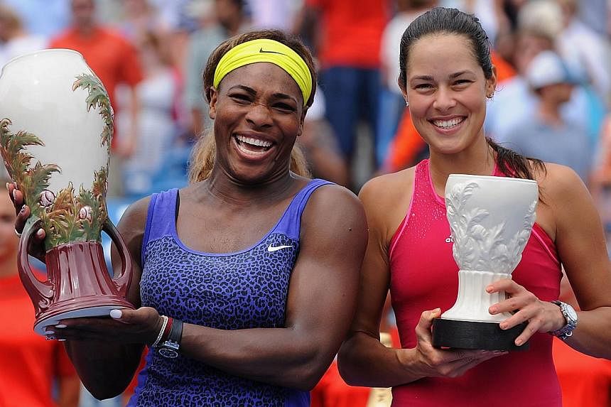 Serena Williams and Ana Ivanovic of Serbia pose with their trophies after the final match on day 9 of the Western &amp; Southern Open at the Linder Family Tennis Centre on August 17, 2014 in Cincinnati, Ohio. -- PHOTO: AFP