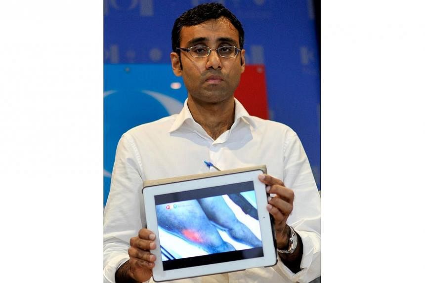 N. Surendran holds up a computer tablet to illustrate an image during a press conference at the People's Justice Party headquarters in Kuala Lumpur on June 1, 2013.&nbsp;Surendran, a lawyer for Malaysian opposition leader Anwar Ibrahim, was charged w