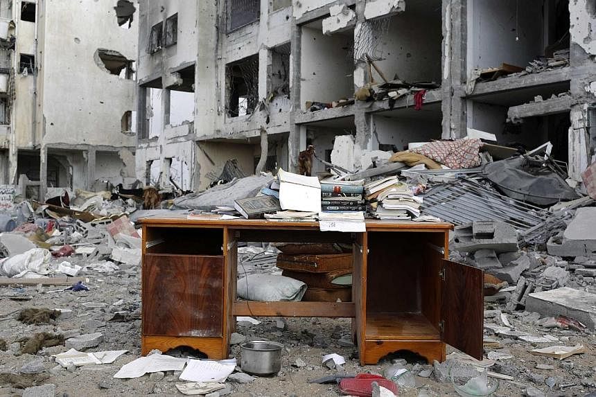 A desk sits amid the debris of buildings destroyed by what police said were Israeli airstrikes and shelling in the town of Beit Lahiya in the northern Gaza Strip on Aug 3, 2014.&nbsp;Israel on Tuesday, Aug 19, ordered a military air strike after thre