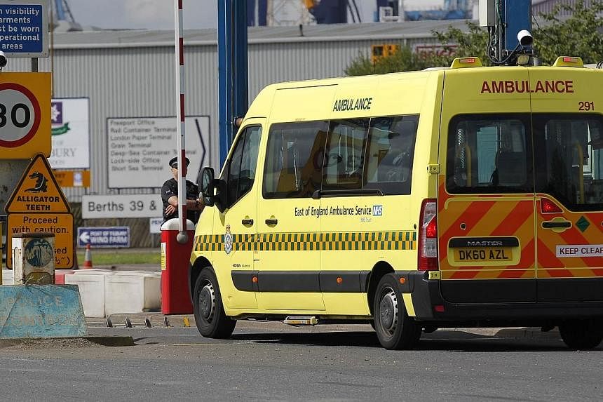 An ambulance arrives at Tilbury Docks, east of London on Aug 16, 2014, where one man was found dead and 19 people, including seven children, were discovered inside a shipping container.&nbsp;A man was arrested in Northern Ireland on Tuesday, Aug 19, 
