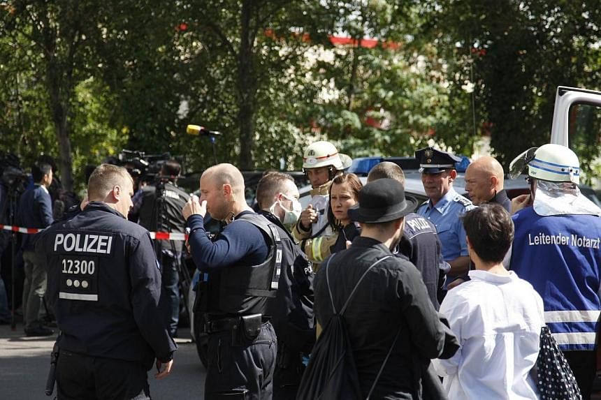 Policemen and emergency doctors stand in front of the employment center in Berlin's Prenzlauer Berg district on Aug 19, 2014, where a woman received medical treatment after she was suspected to have been infected with Ebola.&nbsp;Emergency services i