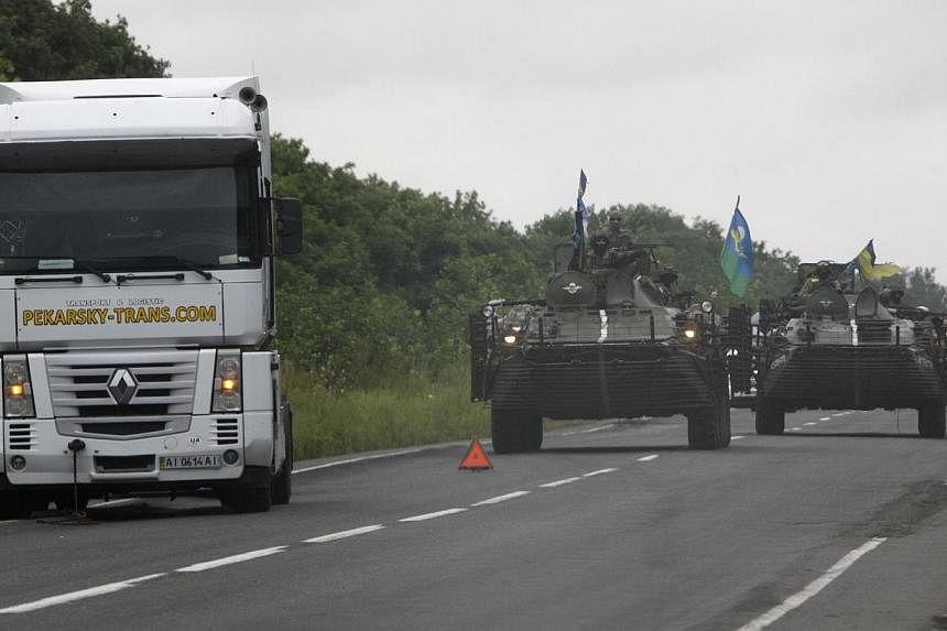 Ukrainian servicemen drive armored vehicles along a road as they patrol the Donetsk region on Aug 18, 2014.&nbsp;Fifteen bodies have so far been recovered from the site of Monday's rocket strike on a refugee convoy of buses and cars in eastern Ukrain