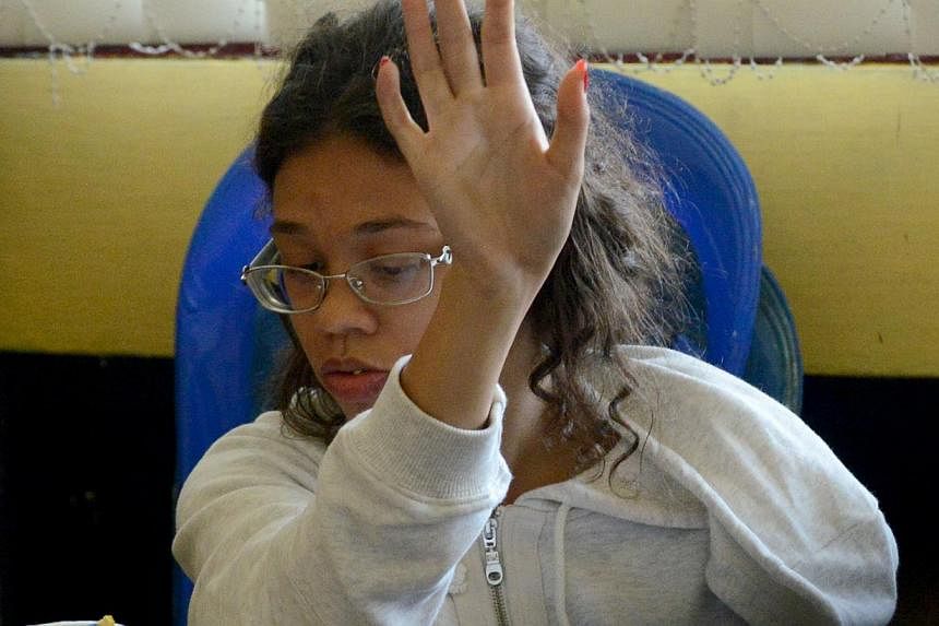 Heather Mack, suspected in the murder of her mother Sheila von Wiese Mack, gestures while in custody at a police station in Denpasar on the Indonesian resort island of Bali on Aug 14, 2014 -- PHOTO: AFP