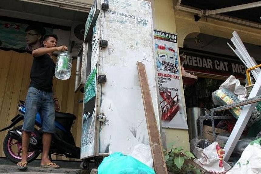 A man collecting water from a water vending machine in Subang Jaya. -- The Star/ASIA NEWS NETWORK &nbsp;