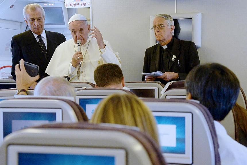 Pope Francis (centre) and Father Federico Lombardi (right) give a press conference aboard the plane carrying the pontiff back to Rome at the end of a five-day trip to South-Korea, on August 18, 2014. -- PHOTO: AFP