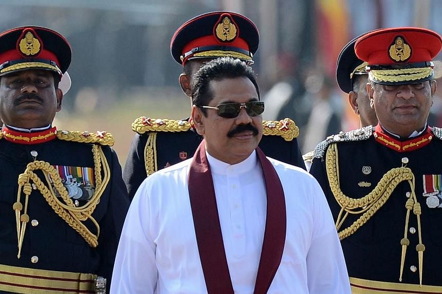 Sri Lankan President Mahinda Rajapakse (centre) looks on as he rides in a vehicle during a Victory Day parade in southern town of Matara on on May 18, 2014. -- PHOTO: AFP