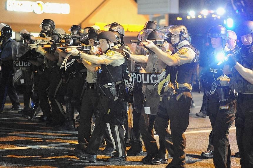 Law enforcement officers watch on during a protest on West Florissant Avenue in Ferguson, Missouri. -- PHOTO: AFP