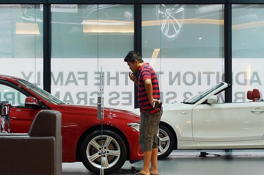 A customer lookiing at a BMW 316i at the Performance Motors showroom on Alexandra Road on 9 September 2013.&nbsp;Certificates of entitlement (COE) for cars all ended higher at the latest tender on Wednesday. -- PHOTO: ST FILE