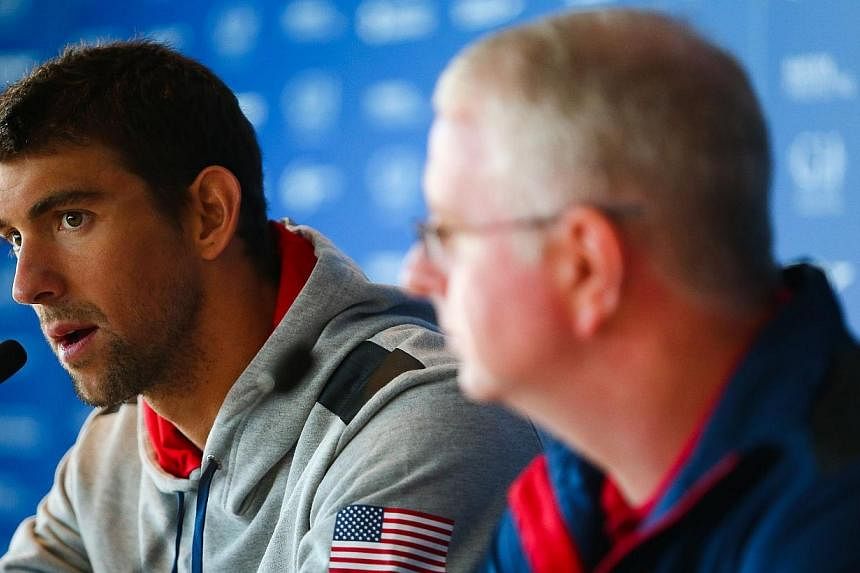 US swimmer Michael Phelps (left) and US swim team coach Bob Bowman (right) take part in a press conference at the Gold Coast Aquatic Centre in Queenland's Gold Coast on August 20, 2014. -- PHOTO: AFP