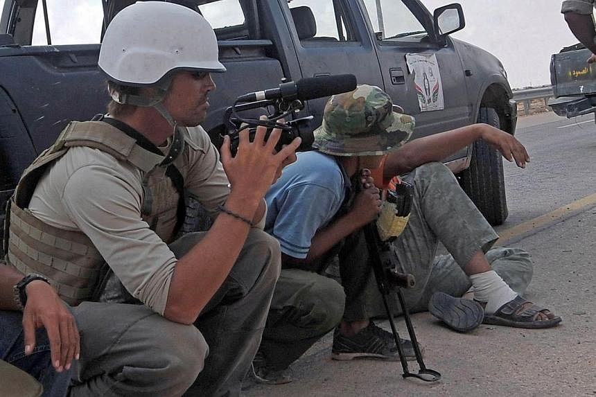 US freelance reporter James Foley (left) on the highway between the airport and the West Gate of Sirte, Libya on Sept 29, 2011.&nbsp;The murder of the American journalist by the so-called Islamic State (ISIS) is the extremist group's "first terrorist