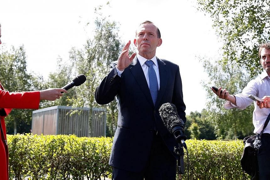 Australian Prime Minister Tony Abbott (centre) speaks to journalists during a visit at Eindhoven's airbase on Aug 11, 2014.&nbsp;A new underwater hunt for missing Malaysia Airlines Flight MH370 had a "reasonable chance" of finding the plane, Australi