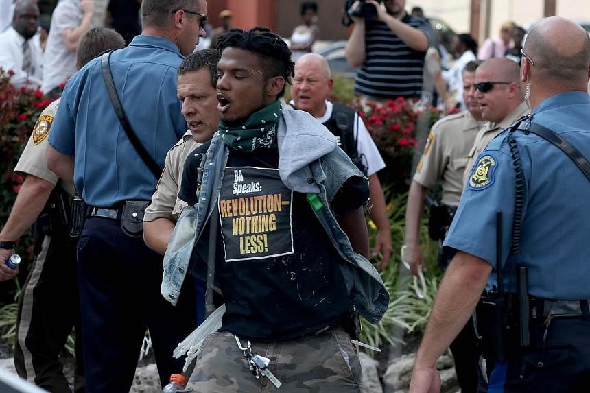 Police arrest a demonstrator protesting the shooting death of Michael Brown on August 18, 2014 in Ferguson, Missouri. Protesters have been vocal asking for justice in the shooting death of Michael Brown by a Ferguson police officer on August 9th. Egy