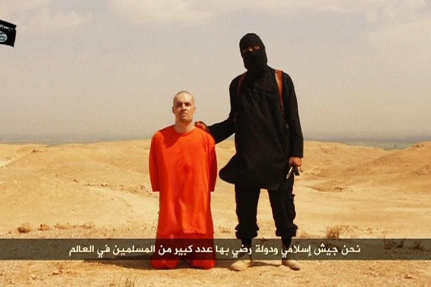 A masked Islamic State militant holding a knife speaks next to man purported to be US journalist James Foley at an unknown location in this still image from an undated video posted on a social media website. Foley's&nbsp;mother said on Tuesday that h
