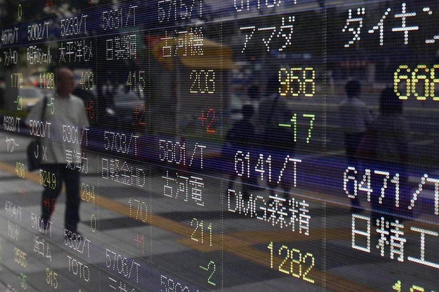 Asian shares slipped Wednesday despite a positive lead from Wall Street, where stocks picked up on encouraging US economic data ahead of a keynote speech this week by the Federal Reserve chief. -- PHOTO: REUTERS