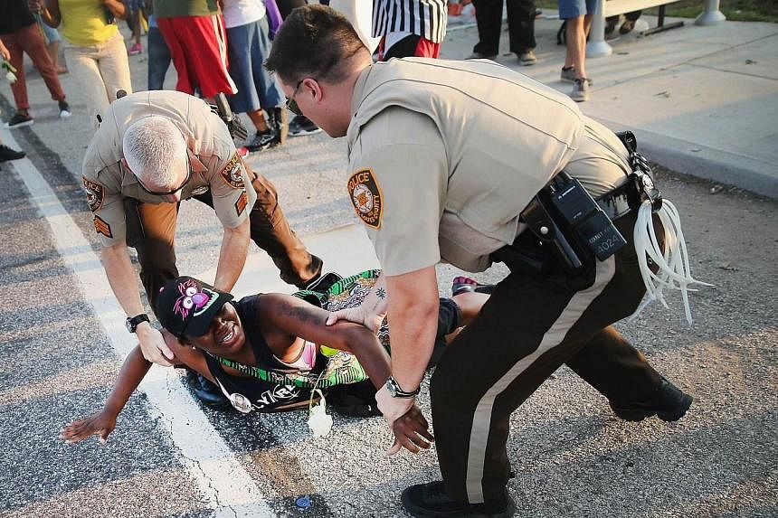 A demonstrator is arrested while protesting the killing of teenager Michael Brown in Ferguson, Missouri on Aug 19, 2014. -- PHOTO: AFP